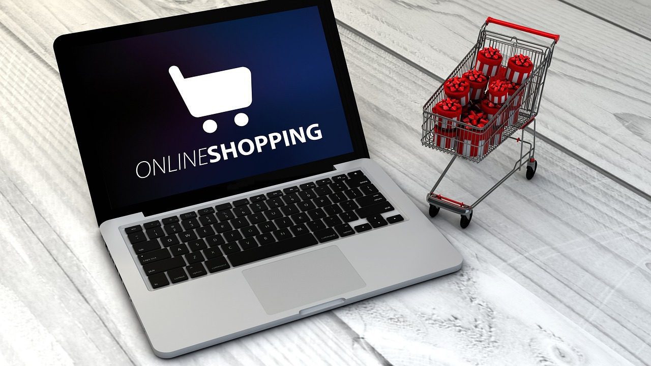 Online shopping with a laptop and a miniature shopping cart