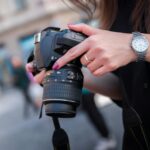 woman holding black dslr camera