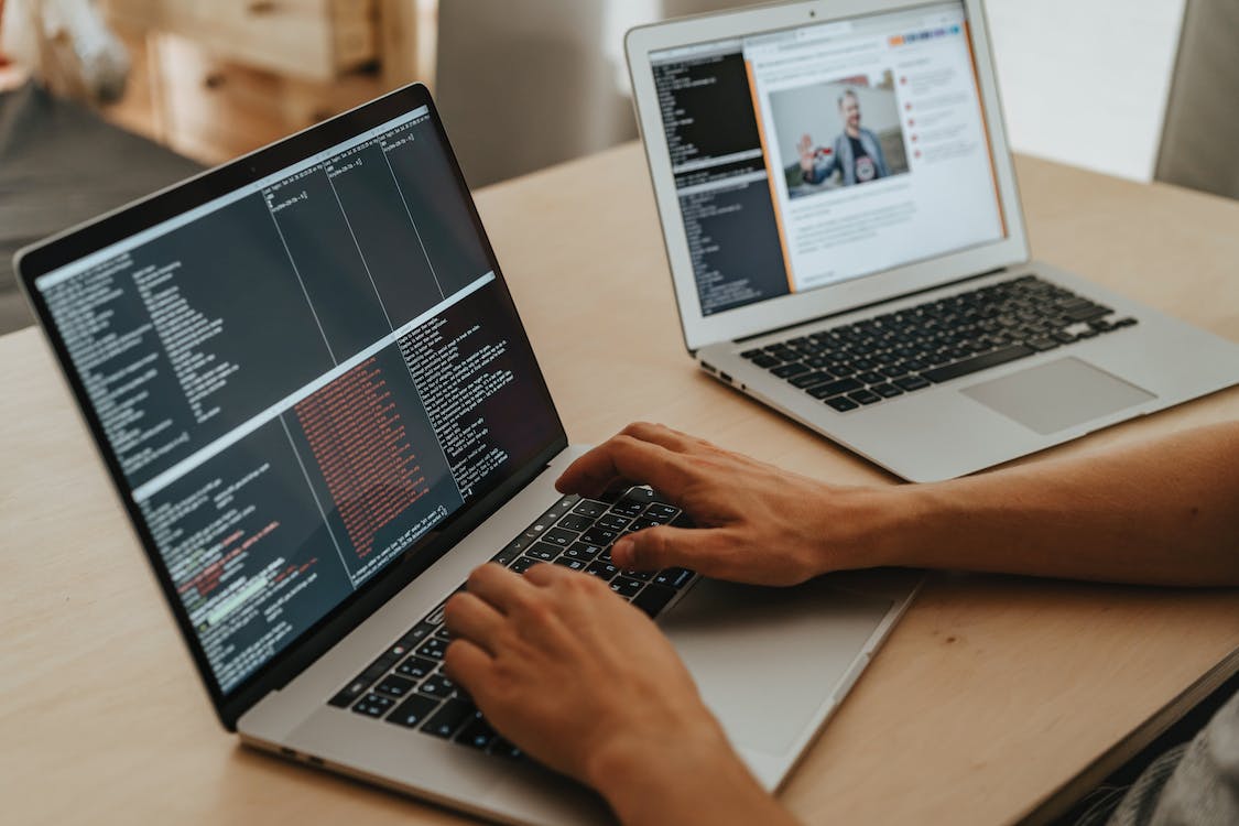 Free Person Coding on a Macbook Pro Stock Photo