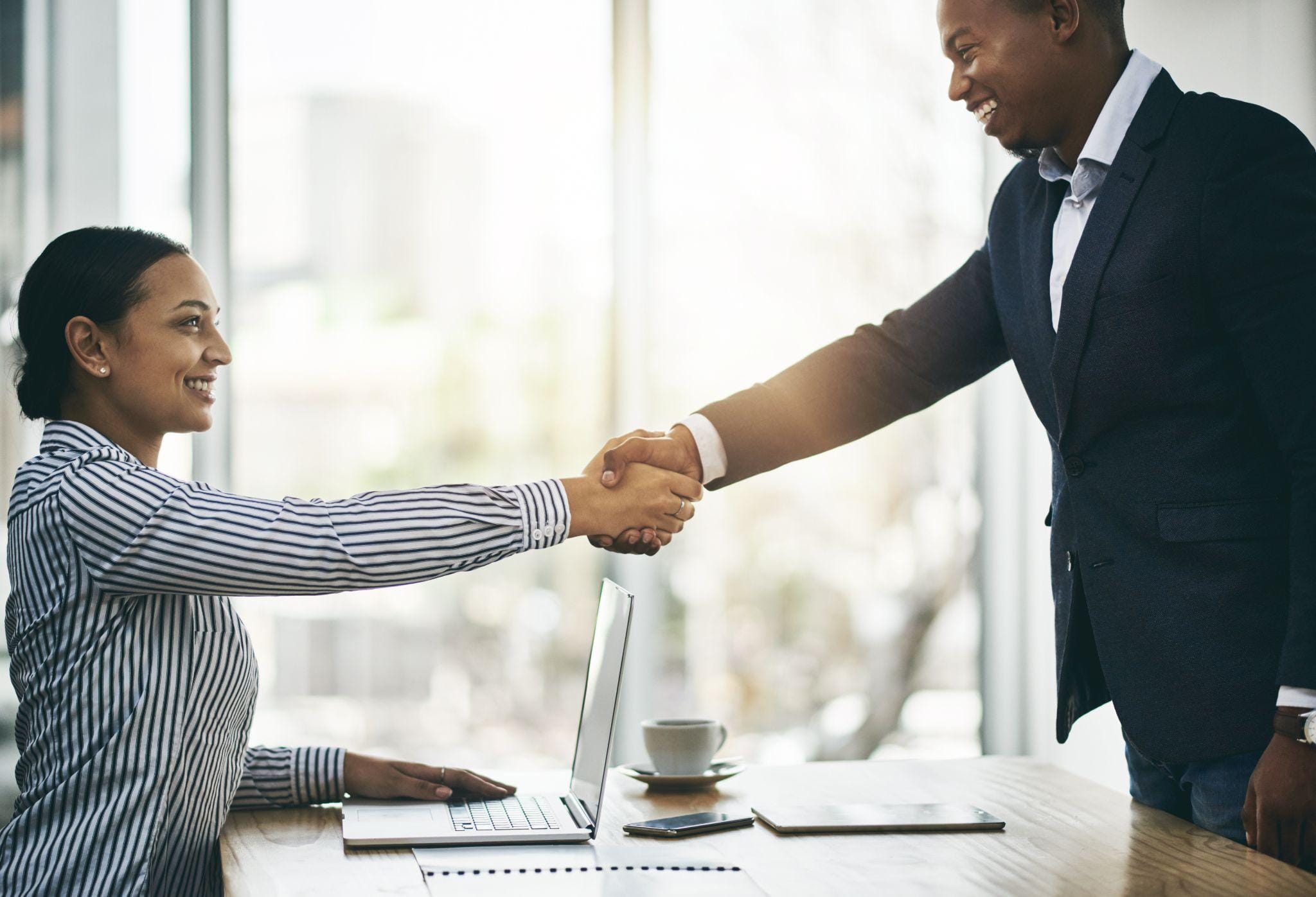  A recruiter shakes hands with a successful candidate.