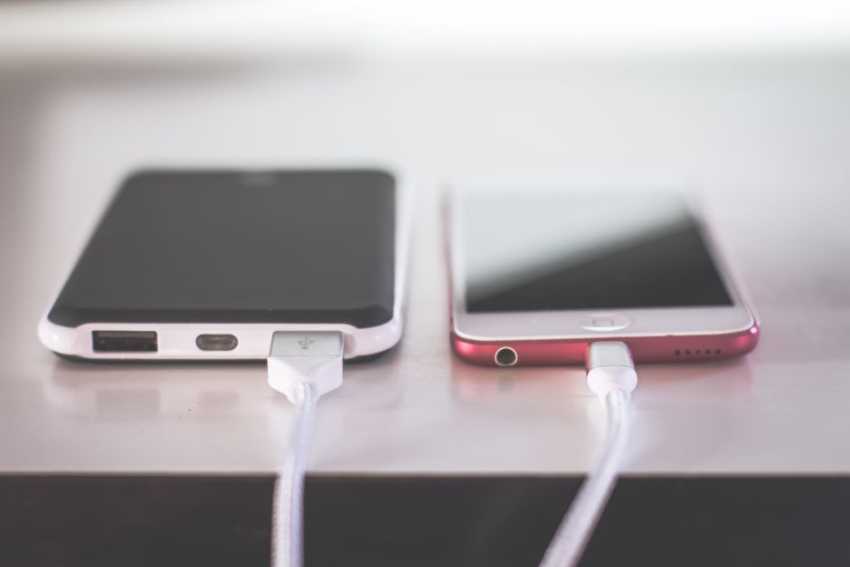 iPhone charging overnight on a bedside table while apps re-download