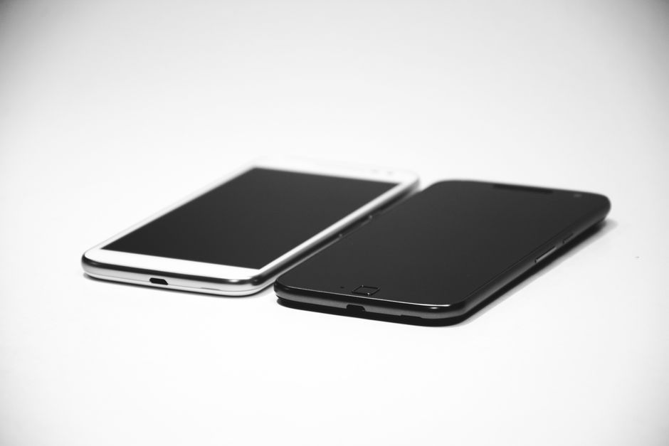 An iPhone-style smartphone and an Android smartphone lying side by side