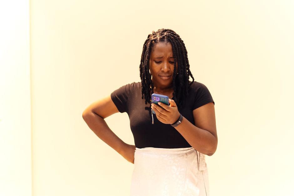 A woman looking at her smartphone while checking a message