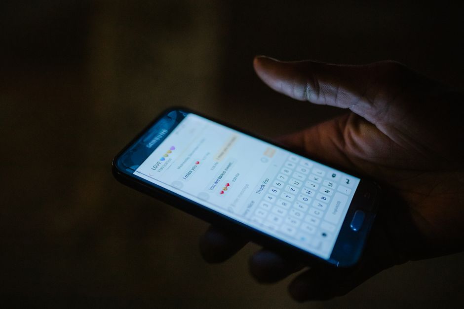 Close-up of a phone screen showing a messaging app in the dark