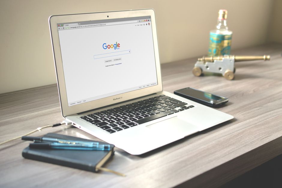 Laptop on a desk displaying the Google search homepage