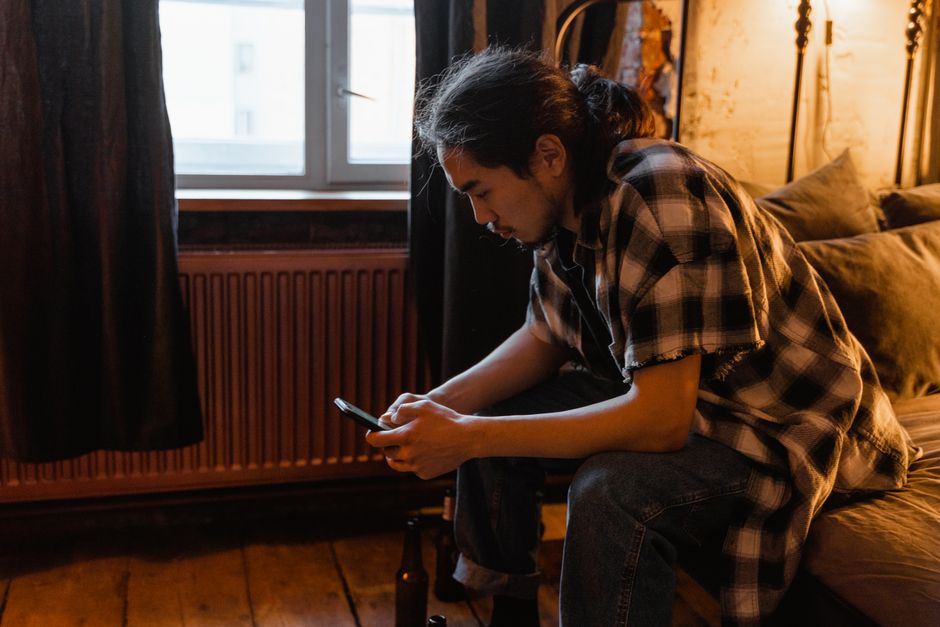Man trying to use a smartphone at home while troubleshooting a connection problem