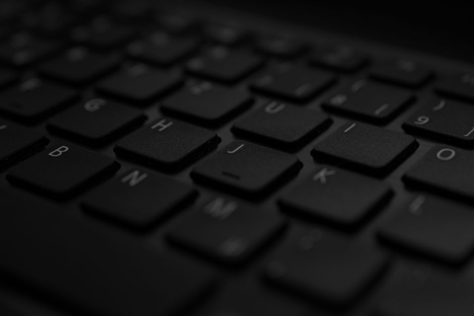 Close-up of a black laptop keyboard with the touchpad visible below